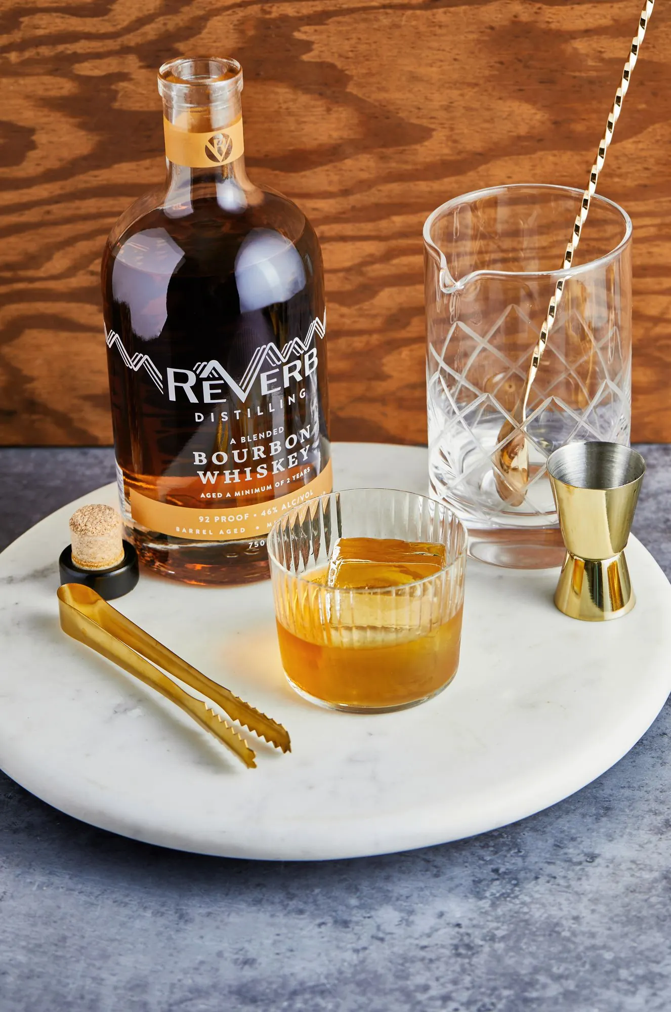 ReVerb Bourbon Whiskey with a rocks glass on a marble tray