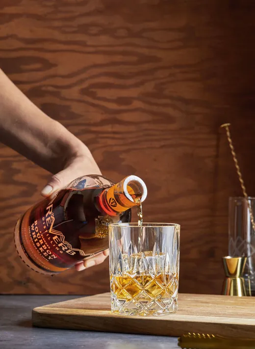 ReVerb Bourbon being poured over a large ice cube
