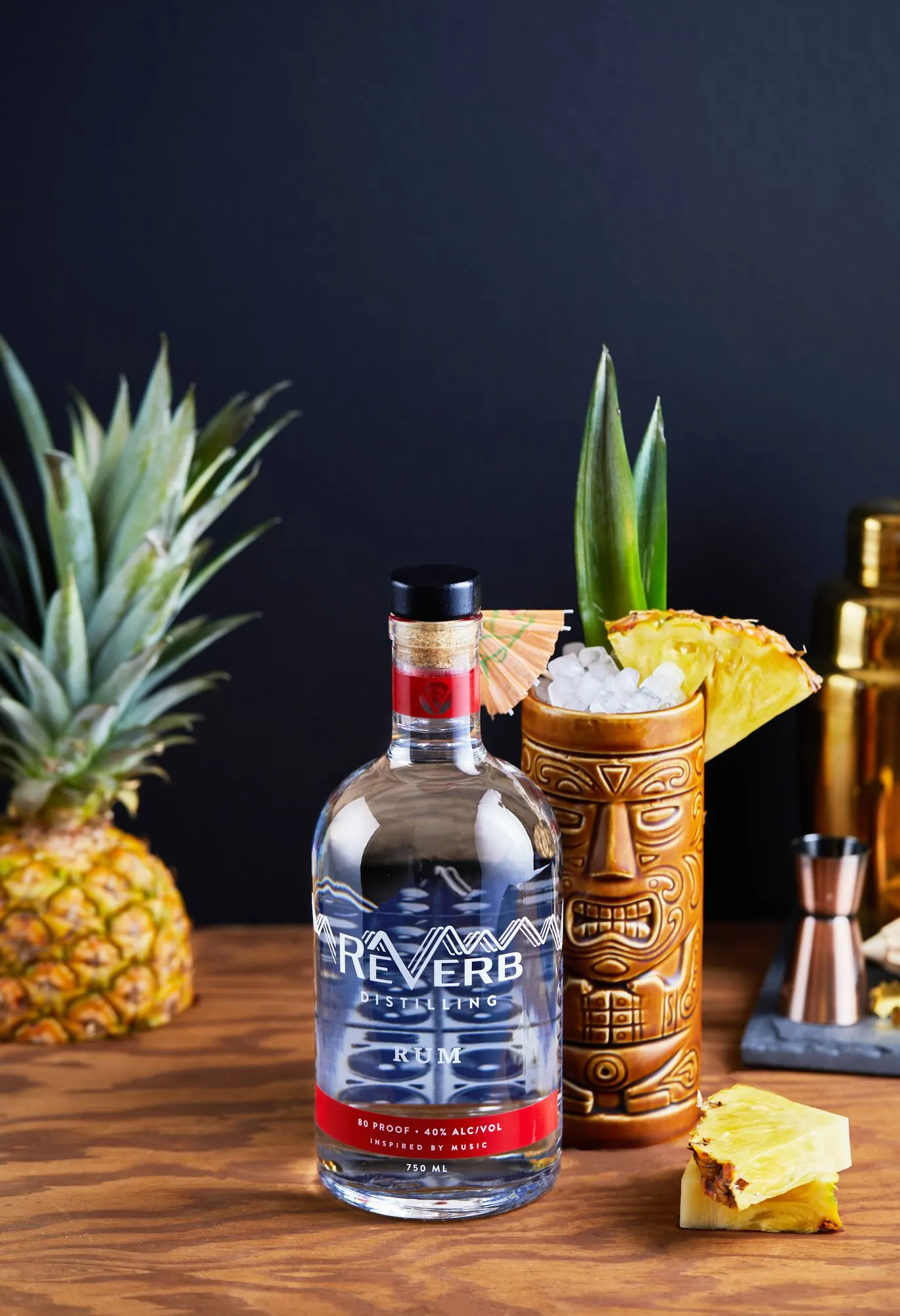 A tiki mug and pineapple beside ReVerb White Rum